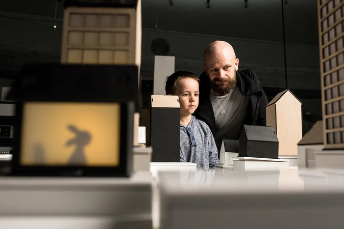 Heurekan Sähkölä-näyttelyssä mies ja poika katsovat puisen kaupunkirakennelman pienoismallia.
