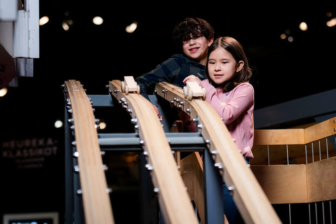 Lapset ovat laittamassa autoja laskemaan Heurekan Ideaverstaan Rakenna mäkiauto -kohteella.