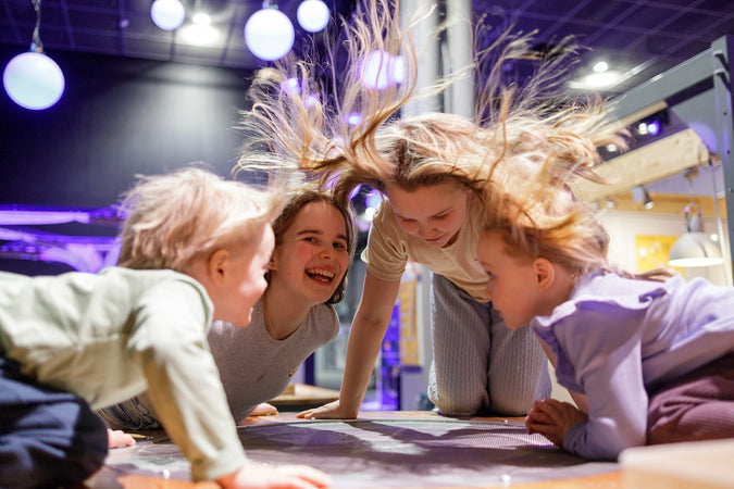 Poika ja kolme tyttöä Leiki ja tutki -näyttelyssä.