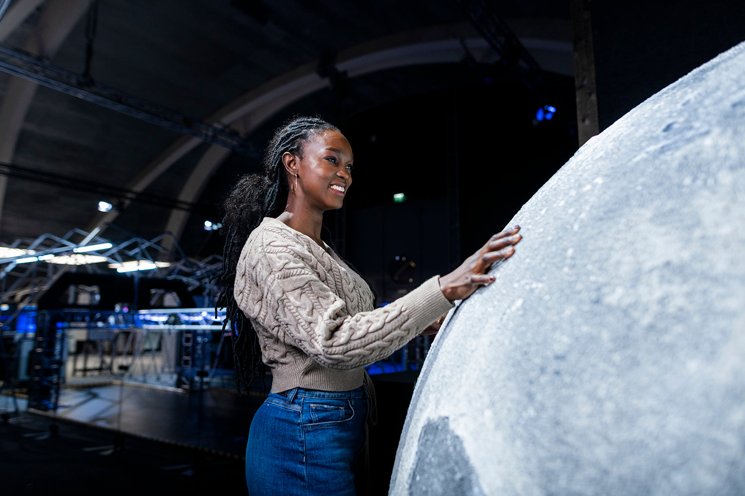 In Heureka's Our Journey in Space exhibition, a dark-skinned, smiling woman touches the surface of the moon.