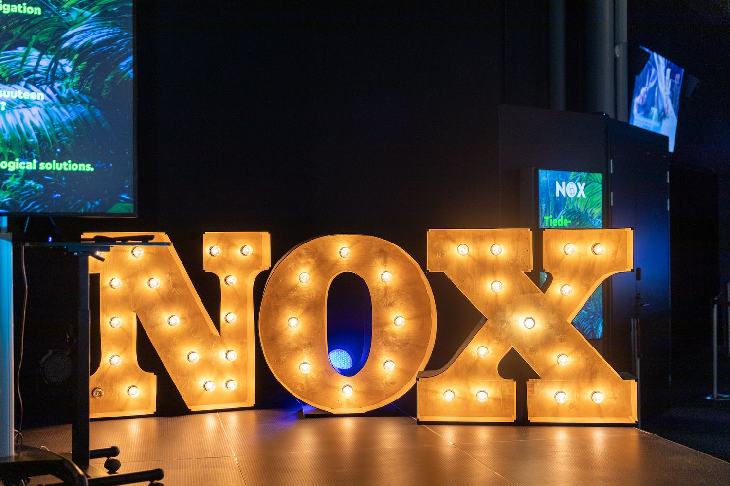 Kolme isoa kirjainvalokylttejä, jotka muodostavat sanan NOX.