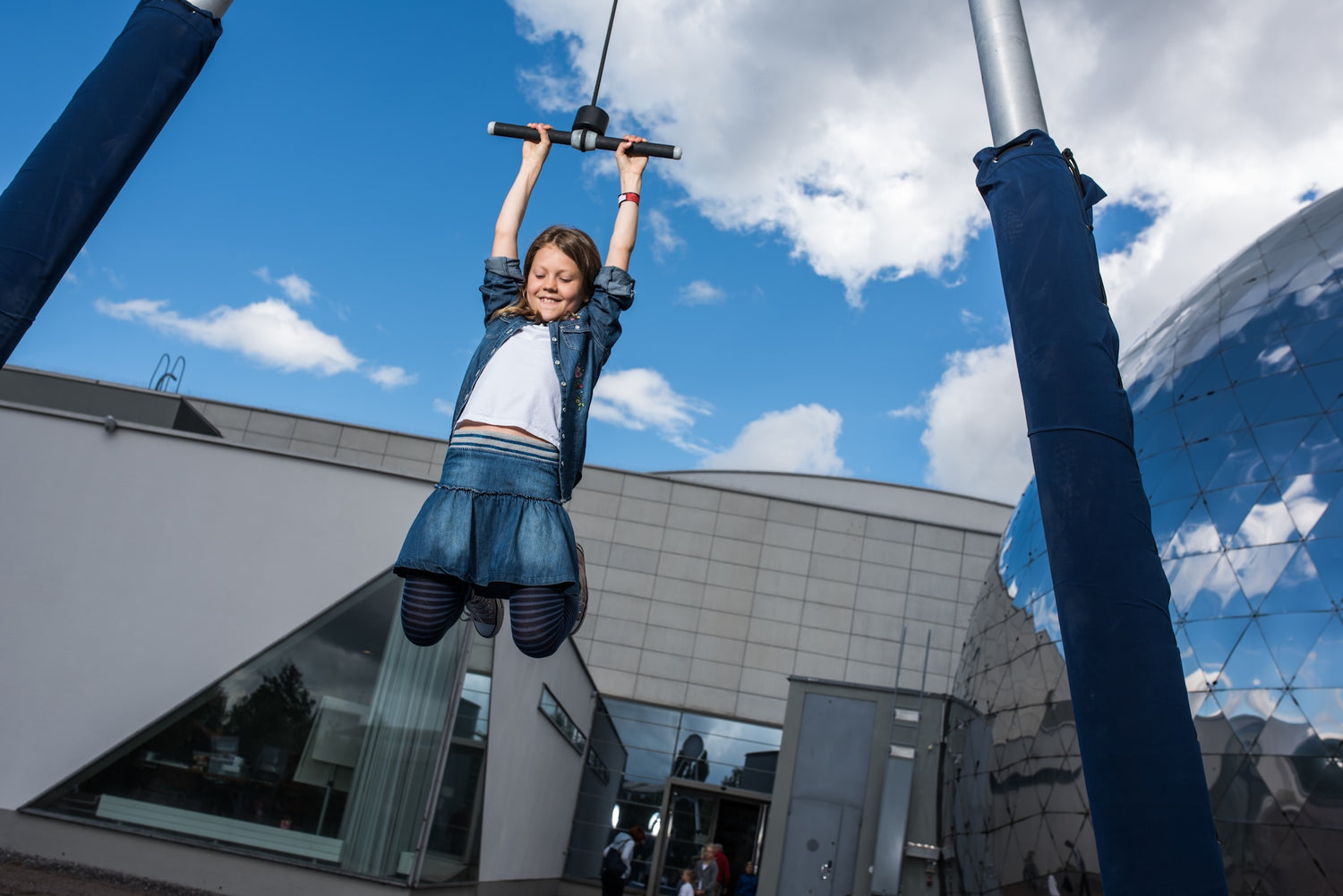 Flicka vid attraktion med mänsklig jojo i Galileo Science Park.