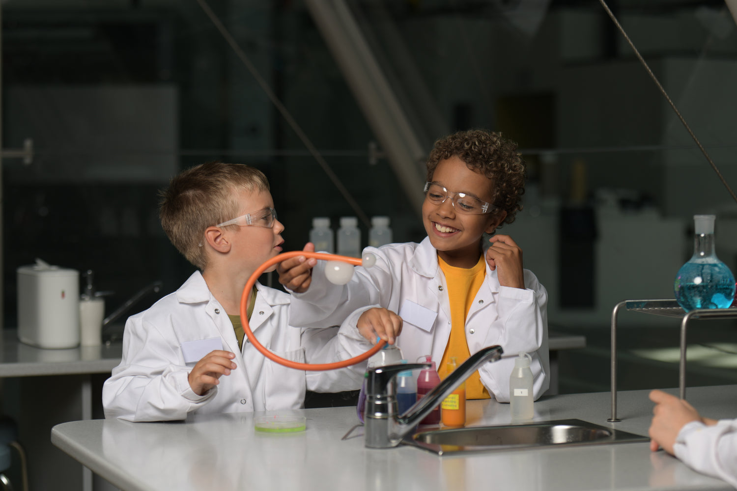 Kaksi laboratoriotakkista poikaa tekee kokeita Heurekan laboratoriossa. 