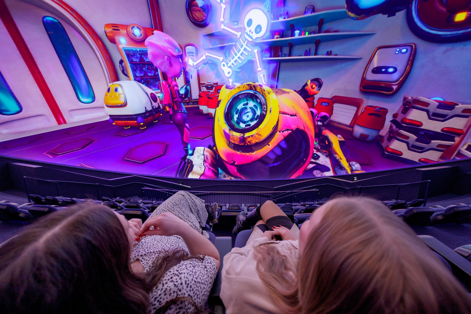 Kaksi naista katsovat planetaarioelokuvaa.