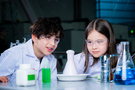 Children looking at a foaming test tube in a laboratory.